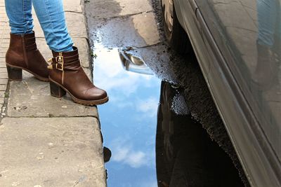 Low section of woman standing on sidewalk