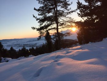 Scenic view of snow covered landscape at sunset