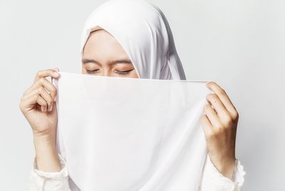 Young woman in hijab against white background