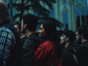 Side view of couple standing against blurred people