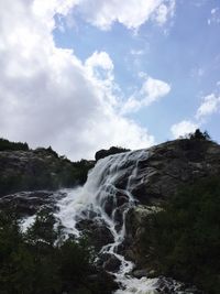 Scenic view of waterfall against sky