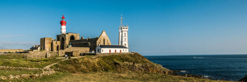 Lighthouse amidst buildings against sky