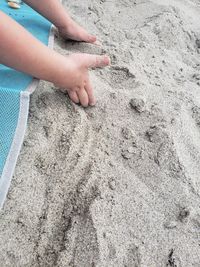 Low section of person on sand at beach