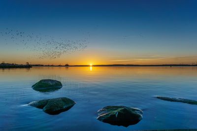 Scenic view of sea against clear sky at sunset