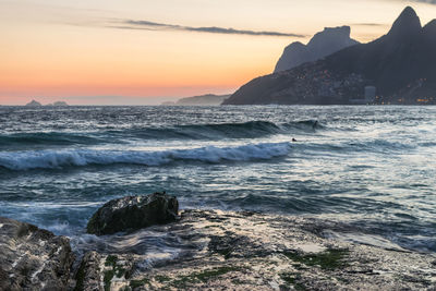 Scenic view of sea against dramatic sky during sunset