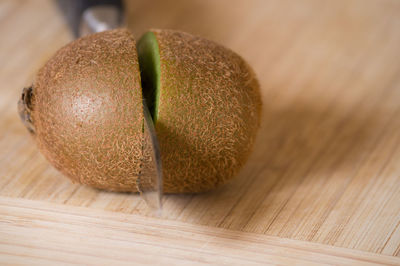 Close-up of sliced kiwi with knife on cutting board