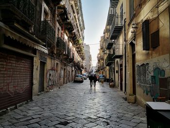 People walking on street amidst buildings in city