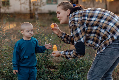 Side view of boy playing with toy on field