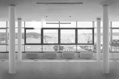 Radiators by glass window in empty room