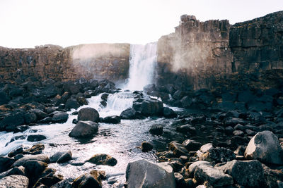 Scenic view of waterfall against sky