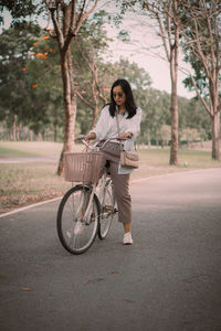 Young woman riding bicycle on road