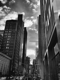 Buildings in city against cloudy sky