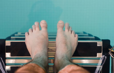 Low section of man relaxing on chair