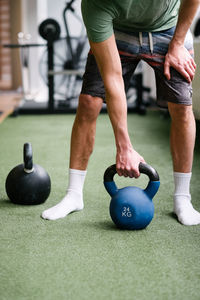 Low section of man standing by ball