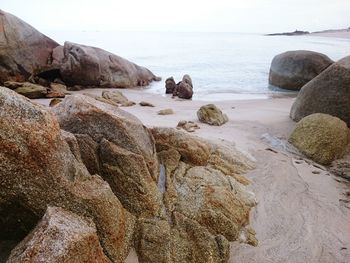 Rocks on beach against sky