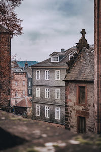 Old building by street against sky