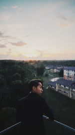 Man standing by tree against sky during sunset