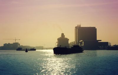 Silhouette ship sailing on sea against sky during sunset