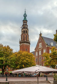 View of buildings in city against cloudy sky