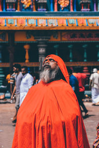 Serious sadhu standing against temple 