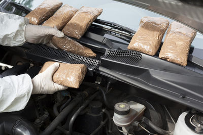 Cropped hands of person repairing car engine