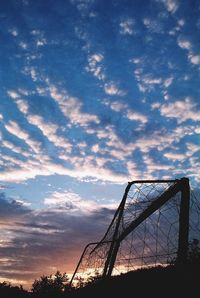 Low angle view of silhouette cranes against sky