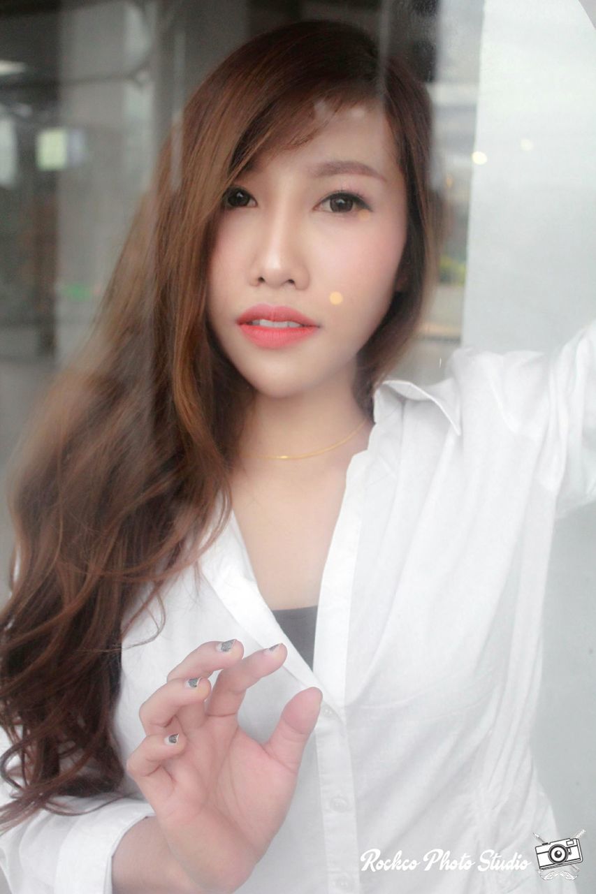 CLOSE-UP PORTRAIT OF BEAUTIFUL YOUNG WOMAN STANDING AGAINST THE WALL