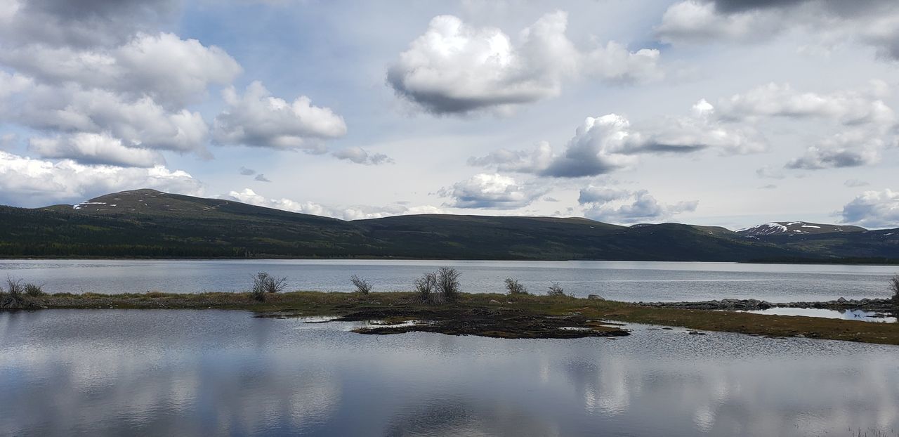 PANORAMIC VIEW OF LAKE AGAINST CLOUDY SKY