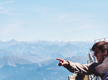 Man pointing against sky