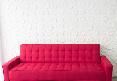 Empty red sofa against wall at home