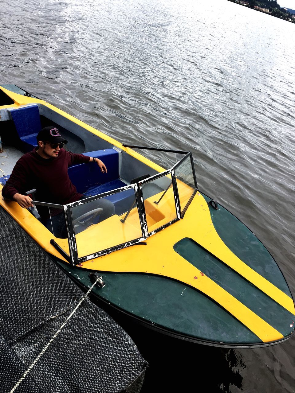 nautical vessel, boat, yellow, water, transportation, real people, mode of transport, one person, river, day, life jacket, leisure activity, outdoors, sitting, lifestyles, moored, oar, sailing, nature, young adult, people