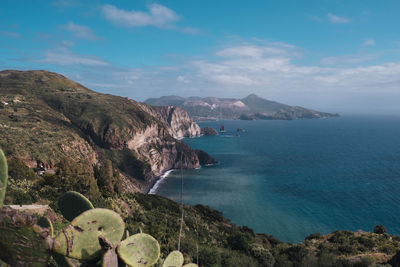 Scenic view of sea and mountains against sky