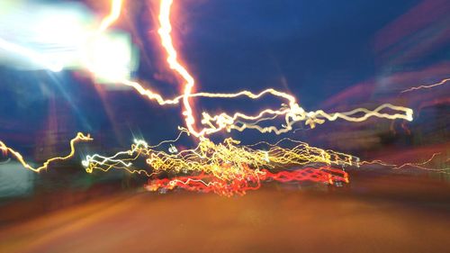 Close-up of illuminated christmas lights against sky at night