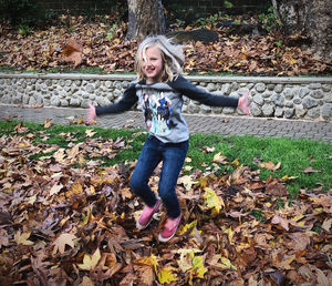 Portrait of smiling boy with leaves during autumn