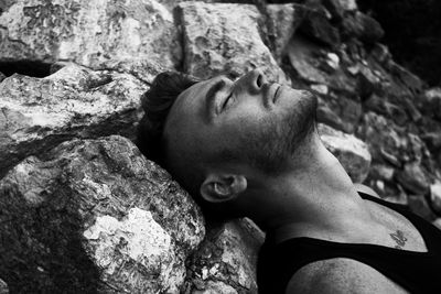 Close-up of man relaxing on rock