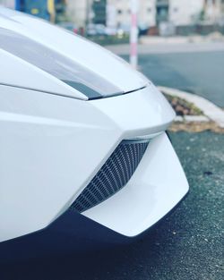 Close-up of white car on street