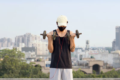 Young man standing against cityscape