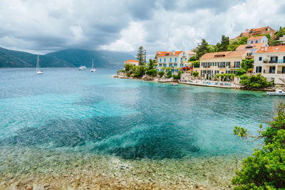 Scenic view of sea by buildings against sky