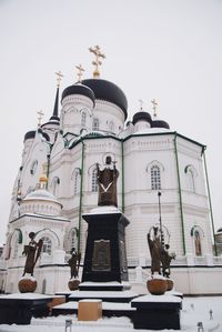 Low angle view of statues on building against sky