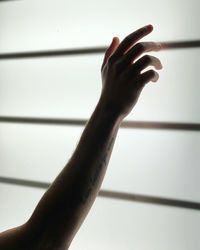 Close-up of hand touching shadow on wall