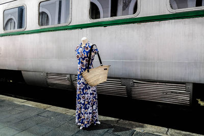 Rear view of a woman standing against built structure