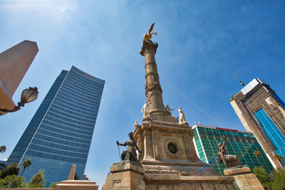 Low angle view of statue of buildings against sky