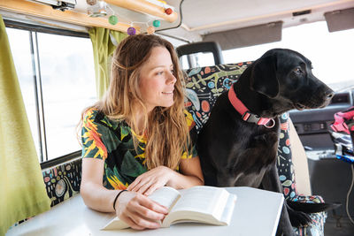 Woman traveling with dog in camper van