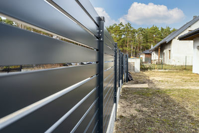 Modern anthracite panel fencing, visible spans and a fence foundation connector, view from garden.