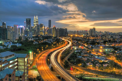 Scenic view of illuminated cityscape against sky at dusk