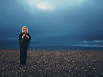 Woman standing on beach against sky