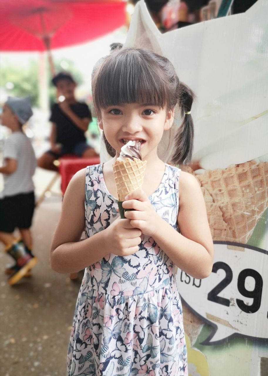 child, sweet food, childhood, ice cream, incidental people, sweet, food and drink, frozen food, food, cone, girls, focus on foreground, one person, ice cream cone, females, women, frozen, front view, real people, innocence, temptation, outdoors