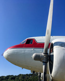 Airplane on airport runway against clear blue sky