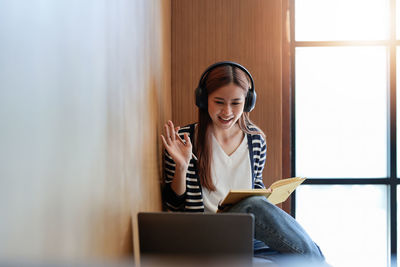 Portrait of young woman using laptop at office