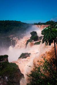 Scenic view of waterfall against sky